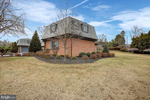 view of home's exterior featuring a garage, a yard, brick siding, and mansard roof