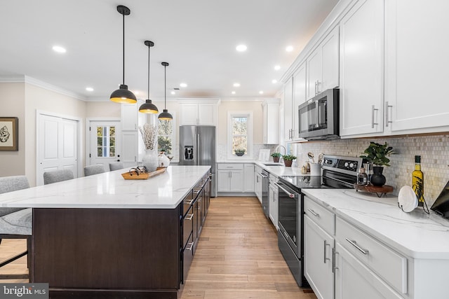 kitchen featuring appliances with stainless steel finishes, crown molding, a sink, and tasteful backsplash