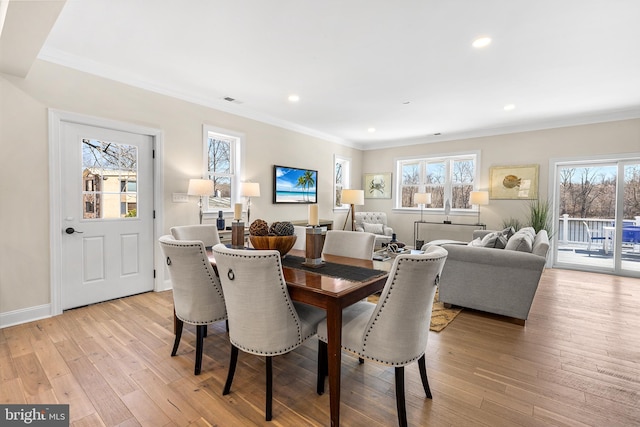 dining space featuring light wood-style floors, baseboards, ornamental molding, and recessed lighting