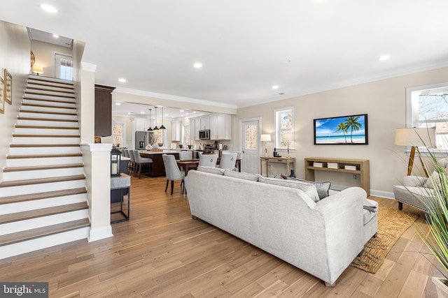 living area with stairs, light wood finished floors, recessed lighting, and crown molding