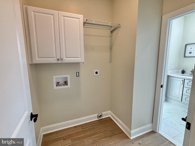 laundry room featuring hookup for a washing machine, cabinet space, hookup for an electric dryer, light wood-type flooring, and baseboards