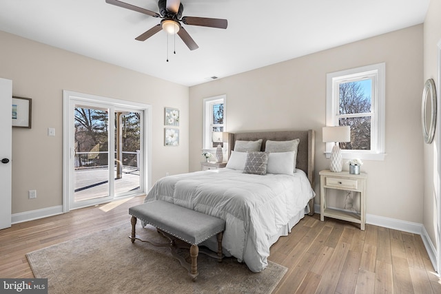 bedroom featuring light wood-type flooring, access to outside, and multiple windows