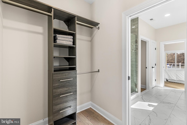 walk in closet with marble finish floor