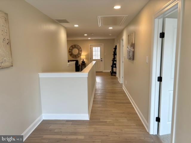 corridor featuring light wood finished floors, recessed lighting, attic access, and baseboards