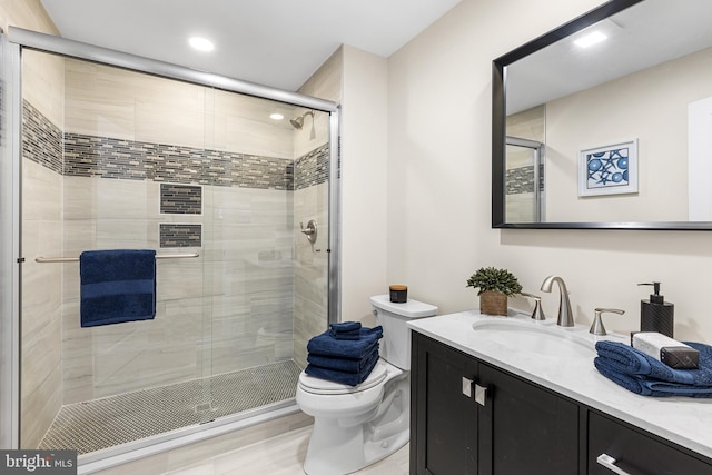 full bathroom with a stall shower, vanity, and toilet