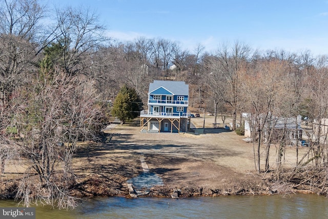 rear view of house featuring a water view and stairs