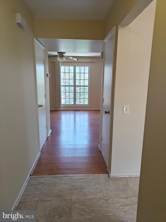 hallway with baseboards and wood finished floors