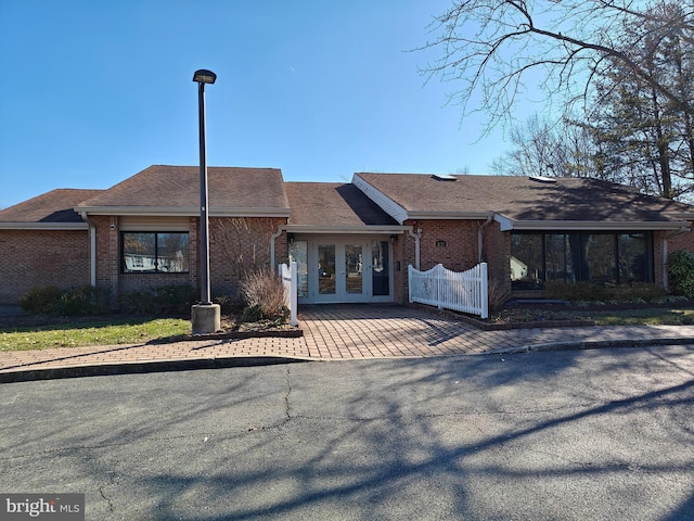 view of front facade with french doors and brick siding