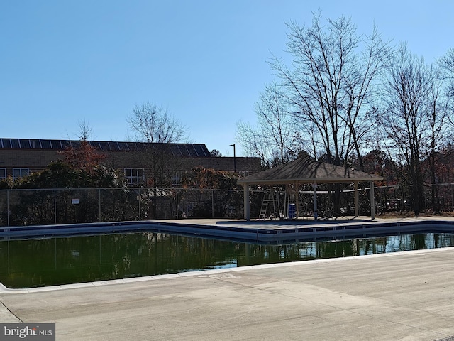 view of pool with fence and a gazebo