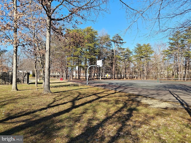 view of property's community with community basketball court, fence, and a yard