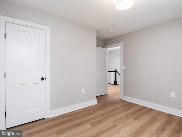 unfurnished bedroom featuring light wood finished floors and baseboards