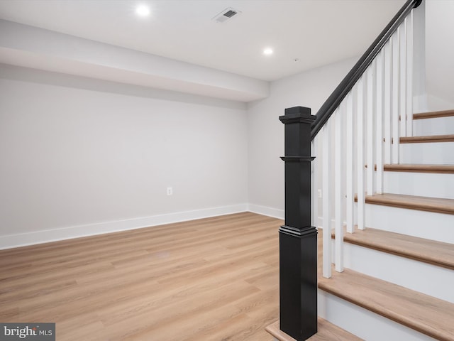 stairway with visible vents, baseboards, wood finished floors, and recessed lighting