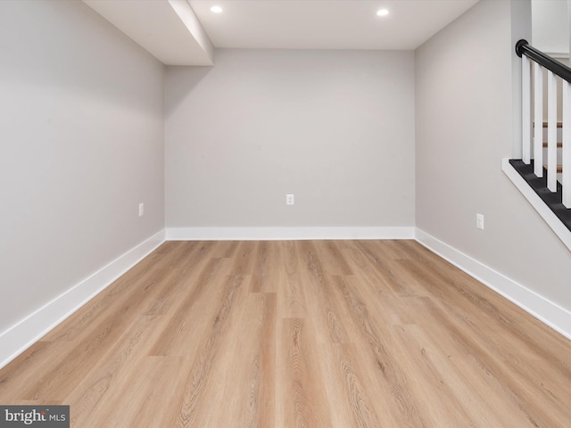 spare room featuring light wood-type flooring, stairway, baseboards, and recessed lighting