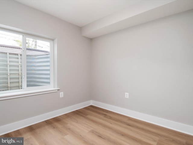 empty room with light wood-style flooring and baseboards