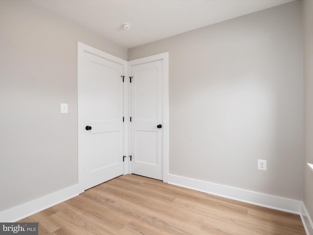 empty room with light wood-style flooring and baseboards