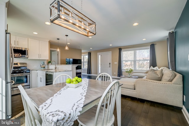 dining space with dark wood-type flooring, recessed lighting, a healthy amount of sunlight, and baseboards