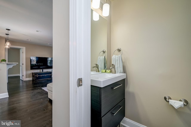 bathroom featuring vanity, baseboards, and wood finished floors