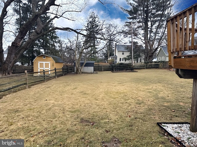 view of yard with a storage unit, an outdoor structure, and a fenced backyard