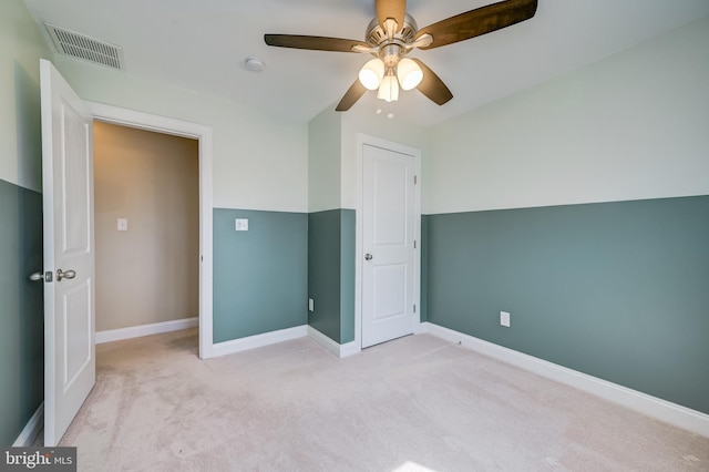 unfurnished bedroom with visible vents, baseboards, carpet, and a ceiling fan