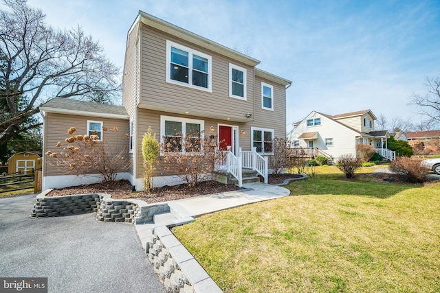 view of front facade featuring a front lawn and fence