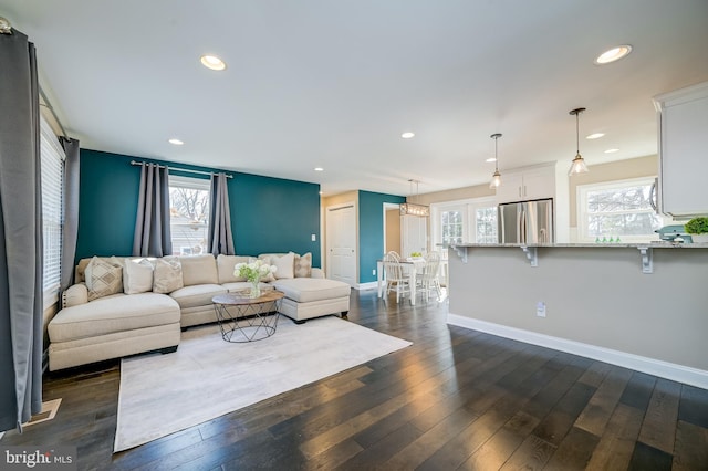 living room with dark wood-type flooring, recessed lighting, and baseboards