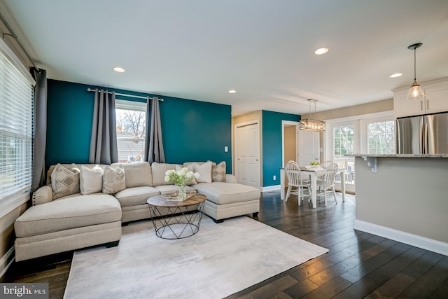 living room featuring recessed lighting, a healthy amount of sunlight, dark wood-style flooring, and baseboards