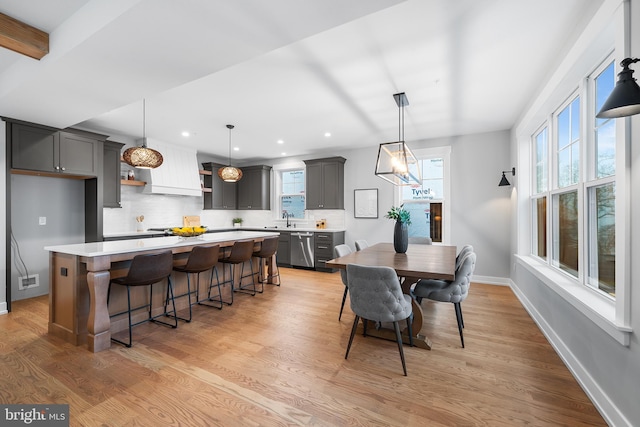 dining area featuring a healthy amount of sunlight, recessed lighting, light wood-style flooring, and baseboards