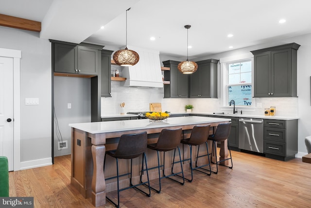 kitchen with light wood finished floors, open shelves, light countertops, premium range hood, and dishwasher