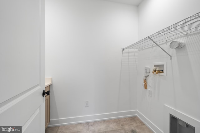 washroom featuring hookup for a washing machine, laundry area, baseboards, and light tile patterned floors