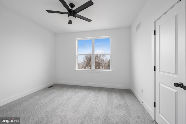 spare room featuring ceiling fan, carpet, visible vents, and baseboards