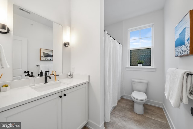 bathroom featuring toilet, visible vents, vanity, baseboards, and tile patterned floors