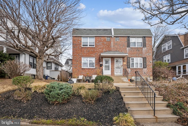 view of front of house featuring brick siding and a shingled roof