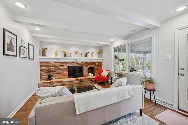 living room featuring a brick fireplace, a baseboard heating unit, baseboards, dark wood finished floors, and beamed ceiling