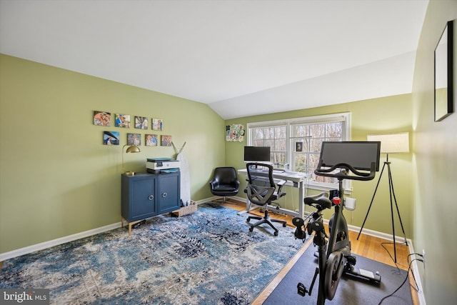 home office featuring vaulted ceiling, wood finished floors, and baseboards