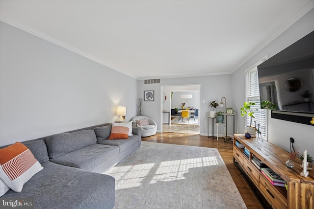 living room featuring visible vents, baseboards, dark wood finished floors, and ornamental molding