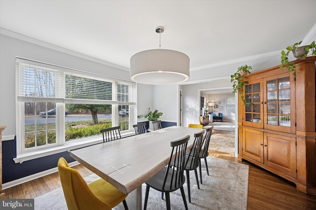 dining space with wood finished floors, baseboards, and ornamental molding