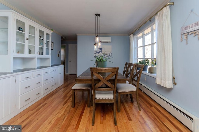 dining area with light wood-type flooring, a baseboard heating unit, a wall unit AC, and ornamental molding