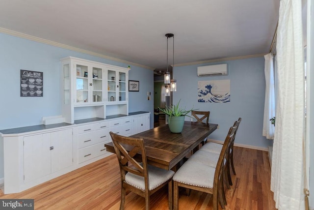 dining space with baseboards, light wood-style flooring, ornamental molding, and a wall unit AC