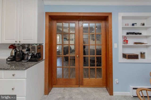 interior space with baseboard heating, built in shelves, white cabinetry, and ornamental molding