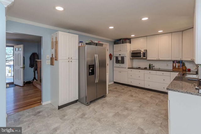 kitchen with decorative backsplash, appliances with stainless steel finishes, white cabinetry, and crown molding