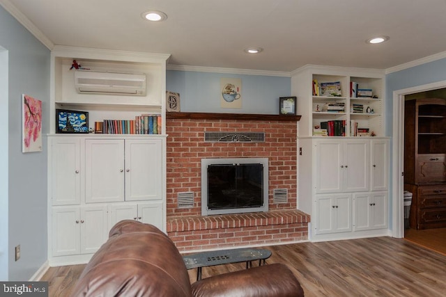 living room featuring crown molding, recessed lighting, a fireplace, wood finished floors, and a wall mounted AC