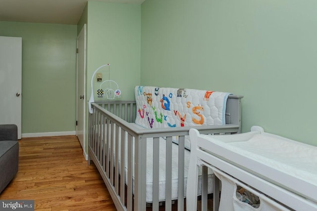 bedroom with wood finished floors and baseboards