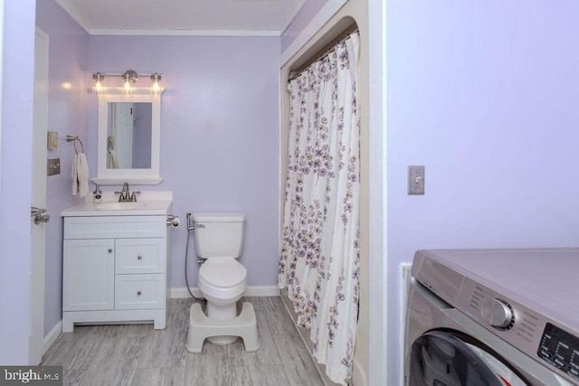 full bath featuring crown molding, baseboards, toilet, washer / dryer, and vanity