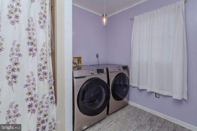 washroom featuring washer and dryer, crown molding, baseboards, and laundry area