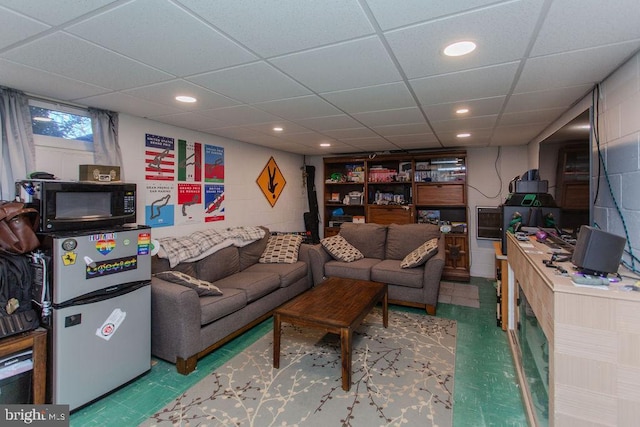 living room with tile patterned floors, concrete block wall, and recessed lighting