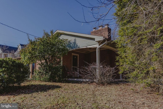 view of property exterior featuring brick siding and a chimney