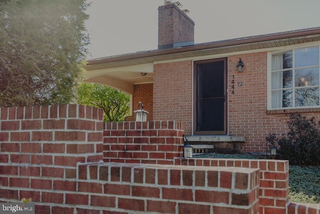 entrance to property featuring brick siding