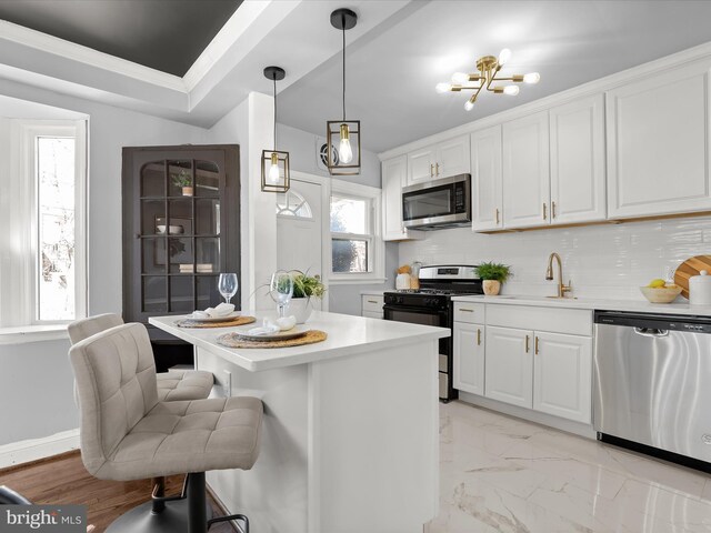 kitchen featuring a sink, tasteful backsplash, appliances with stainless steel finishes, and a healthy amount of sunlight