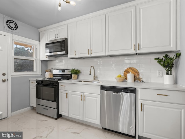 kitchen featuring visible vents, a sink, appliances with stainless steel finishes, white cabinetry, and marble finish floor