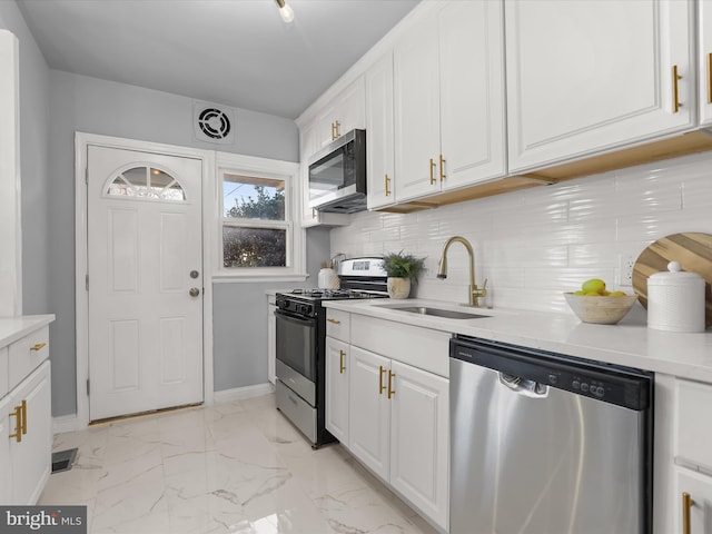 kitchen featuring marble finish floor, appliances with stainless steel finishes, white cabinetry, and a sink